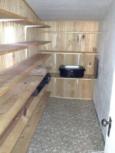 A long shelved pantry off the kitchen to store canned goods.